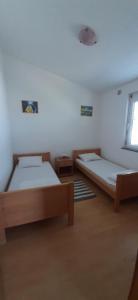 sypialnia z dwoma łóżkami i oknem w obiekcie Villa Dobra Family Apartments w mieście Vir +37 zdjęć