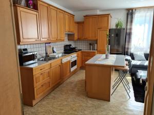 uma cozinha com armários de madeira e uma bancada em Orchidea Apartment em Finkenstein