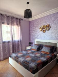 a bedroom with a bed and a purple wall at Bel appartement 3chambres Lilac's Garden Cabo Negro in Cabo Negro +31 photos