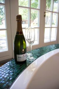 een fles wijn zittend op een tafel met een glas bij Guesthouse "Mirabelle" met indoor jacuzzi, sauna & airco in Tilburg