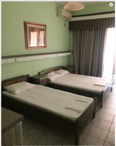 una habitación con dos camas y una ventana en Vila Eva, en Paralia Katerinis