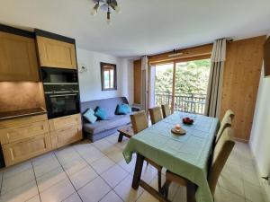een keuken en een woonkamer met een tafel en een bank bij Appartement dans châlet avec piscine couverte in Saint-Gervais-les-Bains