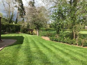 a yard with green grass and trees at Three Gables in Kirklington