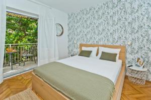 赫瓦尔Hvar Deluxe Rooms的一间带大床的卧室和一个阳台