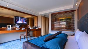 Schlafzimmer mit einem Bett, einem Schreibtisch und einem TV in der Unterkunft Pera Tulip Hotel & Spa - Taksim Pera in Istanbul