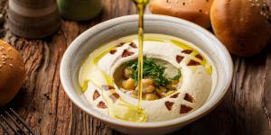 a bowl of soup with beans and cheese on a table at الاطلاله للشقق المخدومة in Khamis Mushayt