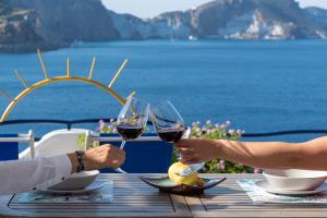 two people sitting at a table with glasses of wine at Maridea - Les Suites Du Soleil in Ponza