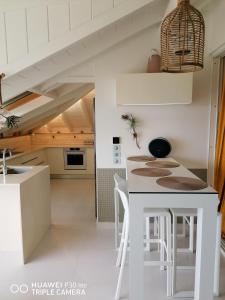 una cucina con tavolo e sgabelli bianchi di Boheme 4 personnes ( 2 chambres ) a Saint-François