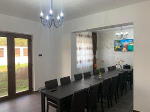uma sala de jantar com uma mesa preta e cadeiras em Pensiunea Alin em Siseştii de Sus