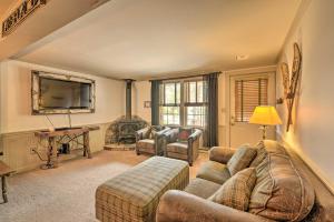 a living room with a couch and a tv at Townhome with Deck Walk to Mirror Lake and Main St! in Lake Placid