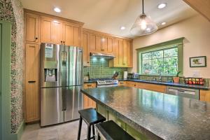 a kitchen with wooden cabinets and a stainless steel refrigerator at Inviting Bungalow with Deck, Close to Dtwn LA! in South Pasadena