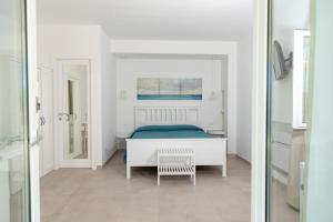 Habitación blanca con cama y espejo en Maridea - Les Suites Du Soleil, en Ponza