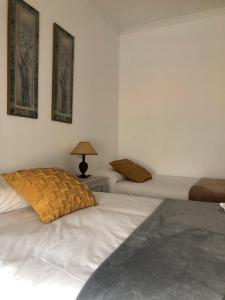 a bedroom with two beds and a lamp on a table at FIFA in Arzúa