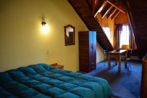 Un dormitorio con una gran cama azul y una mesa en Le Château en San Carlos de Bariloche