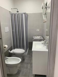 een badkamer met een toilet, een wastafel en een douche bij Appartamenti Mamma Marisa in Minturno