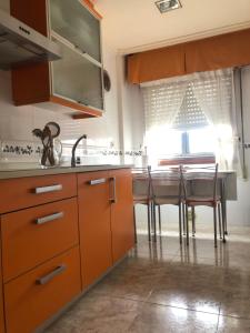 a kitchen with wooden cabinets and a table with chairs at Raquel in Arzúa