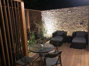 a patio with a table and chairs and a brick wall at La Verda in Bonifacio