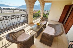 a balcony with wicker chairs and a table with a view at Apartments Rajsko Mjesto in Tivat +47 photos