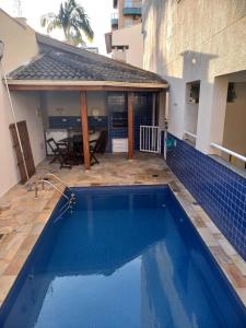 een zwembad in de achtertuin van een huis bij Apt 2 suites com ar condicionado e piscina Ubatuba in Ubatuba