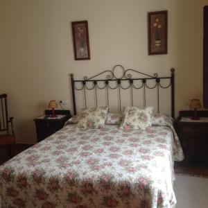 1 dormitorio con 1 cama grande con colcha de flores en Les Piperes, en Corao