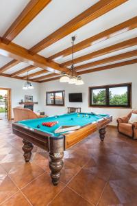 a pool table in a living room with wooden ceilings at Casa 141- familiar conforto paz e bem-estar in Guimarães