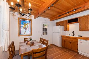 a kitchen with a table and chairs and a kitchen with white appliances at Summit Happy Cabin with HOT TUB! HIGH SPEED EV HOOKUP, CLOSE TO SLOPES in Big Bear Lake
