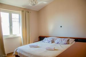 sypialnia z łóżkiem z dwiema poduszkami i oknem w obiekcie Apartments Kraljic w mieście Zadar