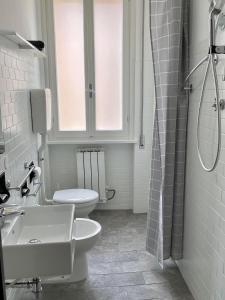 uma casa de banho com 2 WC, um lavatório e um chuveiro em Hotel Villa Serena em Castrocaro Terme
