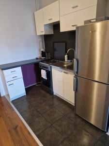 una cucina con frigorifero in acciaio inossidabile e armadietti bianchi di Apartament W2, Mieszkanie dla Wszystkich a Konin