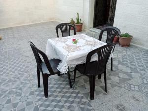 a table with four chairs and a white table cloth at Jerash air apartment in Jerash