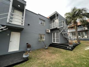 a gray house with a staircase in a yard at Costadorada in Villa Carlos Paz