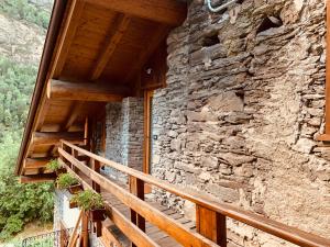 un edificio de piedra con una escalera de madera junto a una pared en Petit Câlin - Le Four des Alpes, en Rhemes-Saint-Georges