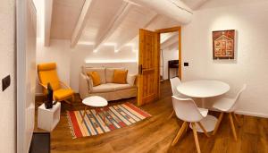 sala de estar con sofá, mesa y sillas en Petit Câlin - Le Four des Alpes en Rhemes-Saint-Georges