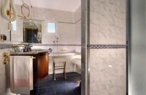 a bathroom with a shower and a sink and a tub at Hotel Atilius & Suites in Riccione