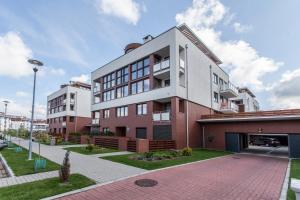 an apartment building with a red and white at Apartamenty Sun & Snow Kołobrzeg Jantar in Kołobrzeg