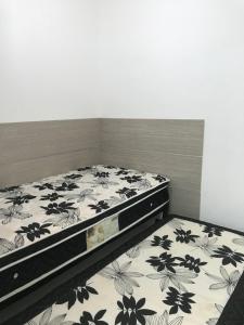 1 Schlafzimmer mit einem Bett mit Blumenbettdecke in der Unterkunft Cobertura Duplex em Condomínio de Alto Luxo - 402 in Cabo Frio