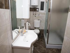 La salle de bains est pourvue d'un lavabo, d'une douche et de toilettes. dans l'établissement Apartments M&R ŠPADINA, à Vodice
