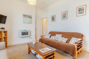 Una sala de estar con un sofá y una mesa de café. en Apartment 1 Llewellan, en Carbis Bay