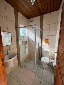 een badkamer met een douche, een toilet en een wastafel bij Pousada Rosália in Penha