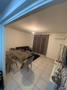 een woonkamer met een bank en een tafel en stoelen bij Grand Appartement lumineux 75m2 in Avignon
