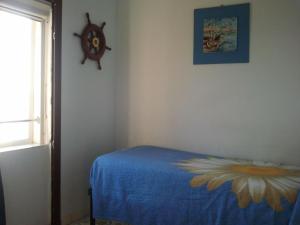 Un dormitorio con una cama azul con una flor en la pared en B&B Borgo Marinaro, en Pozzuoli