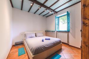 una camera con un letto in una stanza con una finestra di Villa Bog - Villa con piscina e campo da tennis a Piegaro