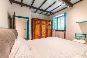 una camera con un letto bianco e una finestra di Villa Bog - Villa con piscina e campo da tennis a Piegaro