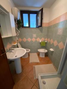 bagno con 2 lavandini, servizi igienici e finestra di Villa Belvedere a Villarios