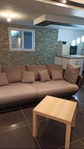Sala de estar con sofá marrón y mesa de centro en chez anita, en Magny-en-Vexin