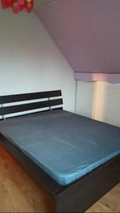 Bett mit blauer Matratze in einem Zimmer in der Unterkunft chez anita in Magny-en-Vexin