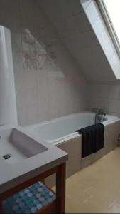 ein Badezimmer mit einer Badewanne und einem Waschbecken in der Unterkunft chez anita in Magny-en-Vexin