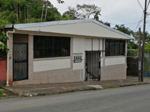 um pequeno edifício com dois portões numa rua em Marta's Guesthouses, apartamentos con entrada autonoma em Puerto Limón