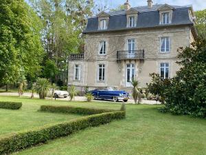 a blue car parked in front of a house at Manoir de la Marjolaine in Cabourg