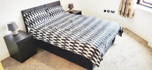 a bedroom with a black and white bed with two night stands at City Centre 1 Bed Apartment in Birmingham